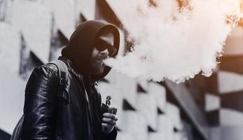 vaping man som håller en mod foto