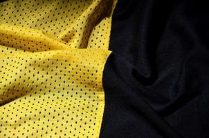 gul sport Kläder tyg textur bakgrund. topp se av gul trasa textil- yta. ljus basketboll skjorta. text Plats foto
