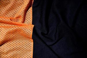sport Kläder tyg textur bakgrund, topp se av orange trasa textil- yta foto