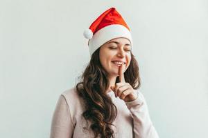 skön flicka i röd santa claus hatt isolerat på vit bakgrund foto