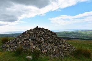 sten röse på de topp av buckla kulle i cumbria foto