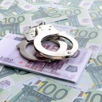 polis handklovar lögner på en uppsättning av grön monetär valörer av 100 euro. en massa av pengar former ett oändlig högen foto
