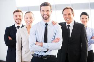 framgångsrik företag team. grupp av självsäker företag människor i formell ha på sig stående stänga till varje Övrig och leende foto
