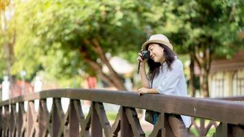 turist resande fotograf framställning bilder flod scape på Foto kamera på bakgrund bro, hipster flicka njuter topp natur Semester