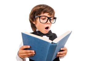 Nej sätt bred vinkel bild av överraskad liten pojke läsning bok och förvaring mun öppen medan stående isolerat på vit foto