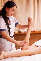 ben massage. självsäker thai massage terapeut masse skön kvinna ben foto