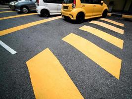 gul fotgängare korsning och gul bil parkerad på de gata foto
