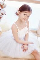 ung ballerina flicka är framställning för en balett prestanda. liten prima balett foto