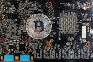 kryptovaluta silver- bitcoin mynt liggande på video kort. elektronisk virtuell pengar för webb bank och internationell nätverk betalning. symbol av crypto virtuell valuta. brytning begrepp. foto