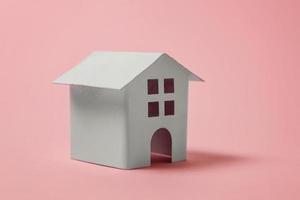 helt enkelt design med miniatyr- vit leksak hus isolerat på rosa pastell färgrik trendig bakgrund. inteckning fast egendom försäkring dröm Hem begrepp. kopia Plats. foto