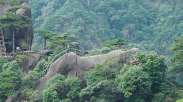 de skön bergen landskap med de grön skog och en planka väg byggd längs de ansikte av en klippa i de landsbygden av de Kina foto
