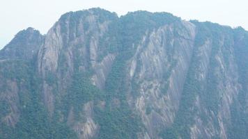 de skön bergen landskap med de grön skog och bröt ut sten klippa som bakgrund i de landsbygden av de Kina foto