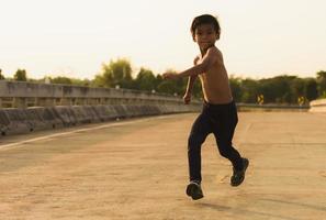 en stark liten pojke sprang längs de bro. foto