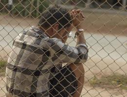 närbild Foto av händer i fängelse stål maska hantera handtag de stål maska bur, saknar oberoende.