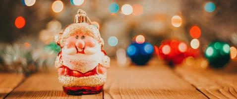 jul bakgrund med gåva lådor, santa claus leksak på trä- bakgrund med krans bokeh. festlig vinter- begrepp. foto