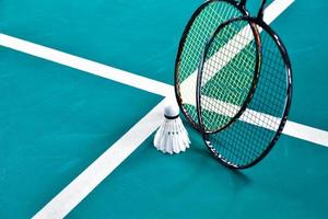 grädde vit badminton fjäderboll och racket på golv i inomhus- badminton domstol, kopia Plats, mjuk och selektiv fokus på fjäderbollar. foto