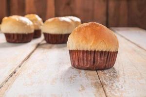färska muffins på ett träbord foto