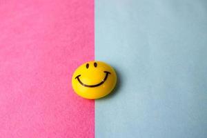 runda plast gul glad leende leende leksak runda ansikte emoji på en rosa blå violett bakgrund foto