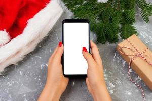 kvinna köpare gör beställa på skärm av smartphone med kopia Plats. jul uppkopplad handla. kvinna köper presenterar för jul. vinter- högtider försäljning foto