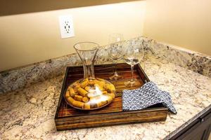 kök granit disken topp med trä- bricka med glasögon och karaff foto
