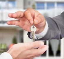 fastighetsmäklare som ger nycklar till ägaren mot nytt hus