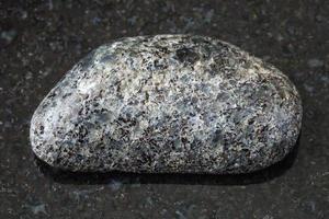 tumlade peridotit sten med flogopit på svart foto