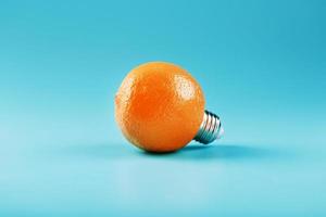 orange ljus Glödlampa på en blå bakgrund. de begrepp av frukt idéer foto