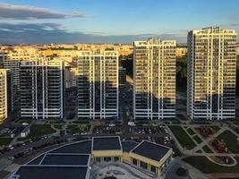 lång blå och vit glas hus är fodrad upp i höjd. hus är tillverkad i de samma stil. ny ovanlig mikrodistrikt tillverkad av glas och metall. i de Centrum är en beige handla foto