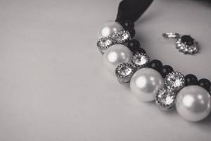 skön dyr dyrbar skinande Smycken modern glamorös Smycken, halsband och örhängen med pärlor och ruter, ruter på en svart och vit bakgrund. platt lägga, topp se, kopia plats foto