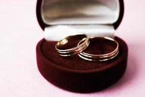 en skön röd festlig gåva låda sammet för två engagemang, bröllop ringar med dyrbar guld runda dyrbar lugg ringar. begrepp äktenskap förslag, bröllop, engagemang foto