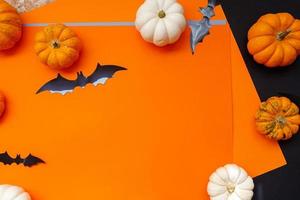 halloween platt lägga sammansättning av svart papper fladdermöss fand pumpor på orange bakgrund. halloween begrepp. foto