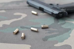 9mm kulor och pistol lögn på kamouflage grön tyg. en uppsättning skytte räckvidd objekt eller en självförsvar utrustning foto