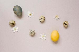 topp se av de Lycklig påsk Semester bakgrund begrepp dekoration arrangemang. där var en vaktel ägg och en kyckling påsk ägg med vit blommor på de beige tabell. foto