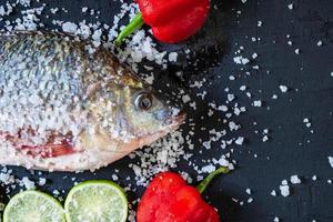 färsk tilapia fisk med salt och kryddor foto