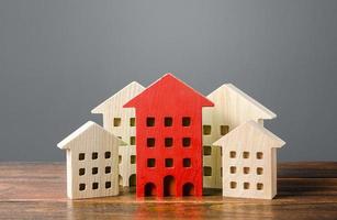 röd figur av en bostads- byggnad står ut bland de resten av de hus. Sök bäst alternativ lägenhet till köpa. kvalitet och Bra plats. reparera och underhåll av de byggnad. i de strålkastare foto