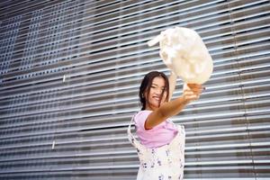 Lycklig ung asiatisk kvinna ser på kamera leende med lycka. foto