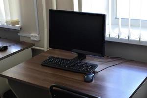 personlig dator på de skrivbord i de kontor. övervaka tangentbord och mus på de tabell. foto