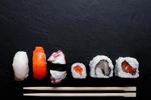 japansk sushi mat. maki ands rullar med tonfisk, lax, räka, krabba och avokado. topp se av blandad sushi. foto
