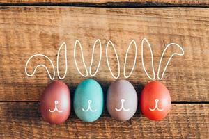 påsk kaniner. topp se av färgad påsk ägg liggande på trä- rustik tabell i en rad foto