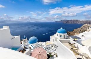 se av oia stad i santorini ö i grekland. känd grekisk landskap, blå kupoler över vit arkitektur. lyx sommar Semester destination, romantisk resa naturskön. skön stadsbild och blå hav foto