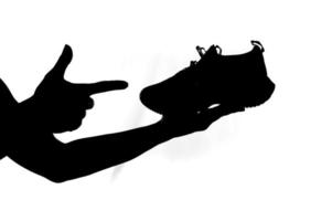 mannens hand innehav en löpning sko på en vit bakgrund. idéer för uppköp löpning skor och träning. foto