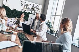 passionerad handla om deras projekt. två modern ung kollegor ledande en företag presentation medan arbetssätt i de kontor foto