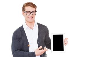 din annons på hans läsplatta. glad ung man innehav en digital läsplatta och pekande den medan stående isolerat på vit foto