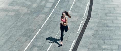 topp se av skön ung kvinna i sporter Kläder löpning utomhus foto