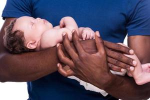 far och son. närbild av afrikansk man innehav hans liten bebis medan stående isolerat på vit foto