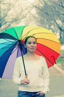 ung kvinna med stort regnbågsparaply