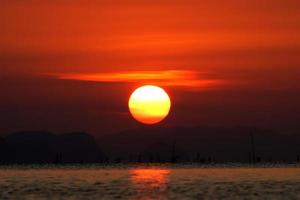 solnedgånghimmel och stor sol, Thailand. foto