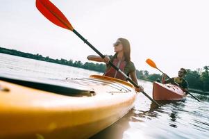 par Kajakpaddling. skön ung par Kajakpaddling på sjö tillsammans och leende foto