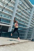 självsäker ung kvinna i sporter Kläder löpning utomhus foto
