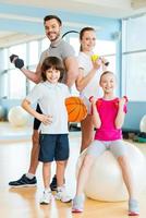 sportig familj. Lycklig familj innehav annorlunda sporter Utrustning medan stående stänga till varje Övrig i hälsa klubb foto